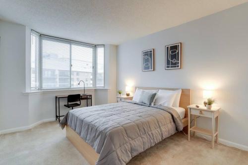 1 dormitorio con cama, escritorio y ventana en Fantastic 2 BR Condo at Ballston With City View en Arlington