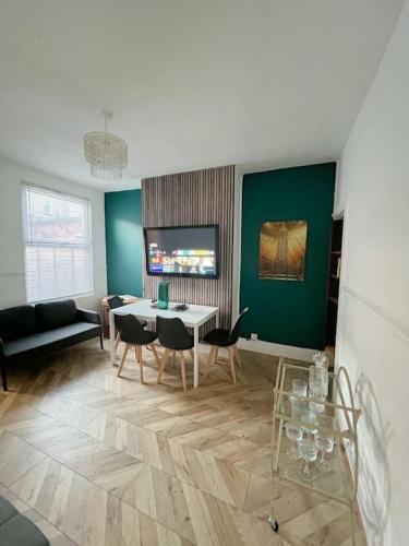 uma sala de estar com uma mesa e cadeiras e um sofá em City centre terrace town house em Nottingham