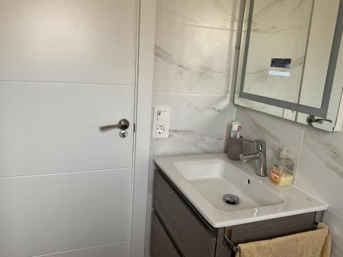 a white bathroom with a sink and a mirror at Casa con Gran Piscina particular cerca playa in Torredembarra