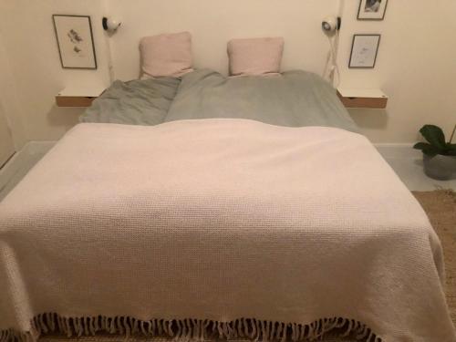 a bedroom with a bed with a white blanket at Nyhavn Apartment in Copenhagen