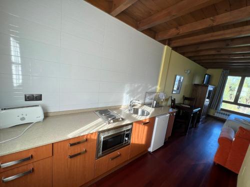 a kitchen with a sink and a stove top oven at Apartamentos Monterodiles in Liñero