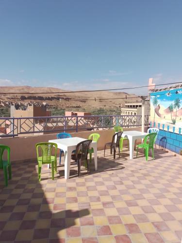 a patio with tables and chairs on a roof at Auberge Restaurant Rooftop Tamazirt in Boumalne