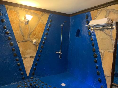 a blue bathroom with a shower with a blue wall at Le Bambou Gorilla Lodge in Ruhengeri