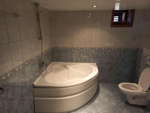a bathroom with a toilet and a white tub at 4 yatak odalı Harika müstakil villa in Manavgat