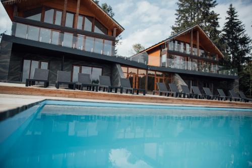 a house with a swimming pool in front of a house at SevenHills chalet in Yablunytsya