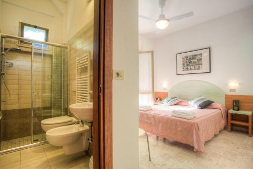 sypialnia z łóżkiem oraz łazienka z prysznicem w obiekcie Albergo Villa Lucia w mieście Bellaria-Igea Marina