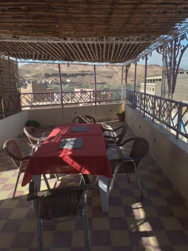 a table and chairs on the balcony of a house at Auberge Restaurant Rooftop Tamazirt in Boumalne