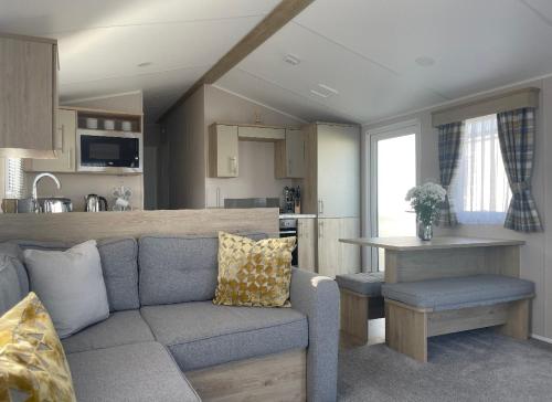 ein Wohnzimmer mit einem Sofa und einer Küche in der Unterkunft Newperran 102 in Cubert