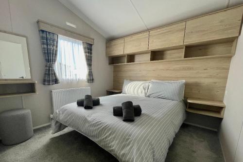 ein Schlafzimmer mit einem großen Bett mit zwei schwarzen Objekten darauf in der Unterkunft Newperran 102 in Cubert