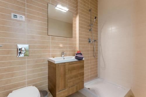 um banheiro com uma pia, um vaso sanitário e um espelho em Burgau 2floor appt in condominium w/ shared pool no Burgau