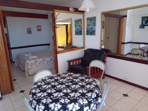 a room with a table and a bed and a mirror at DEPARTAMENTO BARILOCHE centro in San Carlos de Bariloche