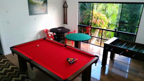 a red pool table in a room with a window at Pousada Hang Conectada com a Natureza in Florianópolis