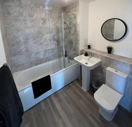 een badkamer met een douche, een toilet en een wastafel bij Riverside Apartment Chelmsford in Chelmsford