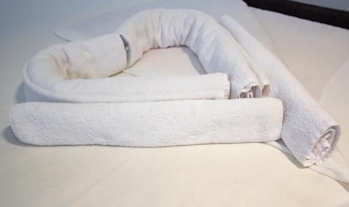 a couple of towels sitting on top of a bed at Hotel Grand in Banja Luka