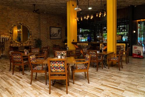 - un restaurant avec des tables et des chaises en bois dans une chambre dans l'établissement Hotel El Meson, à La Dorada
