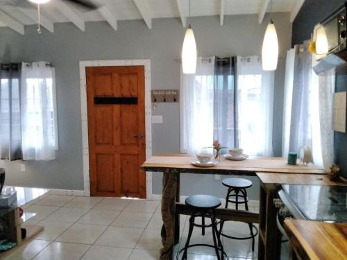 a kitchen with a table and two bar stools at Blue Bahia Resort in Sandy Bay