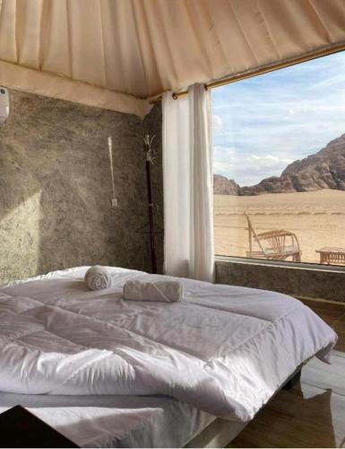 a bedroom with a bed with a view of the desert at Ammar Rum Camp and tours in Wadi Rum