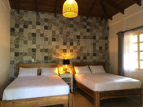 a bedroom with two beds and a chandelier at Hotel Villas Gaia Ecolodge in Uvita