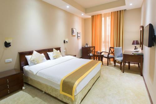 Cette chambre comprend un lit et un bureau. dans l'établissement Diamond Hotel Yerevan, à Erevan