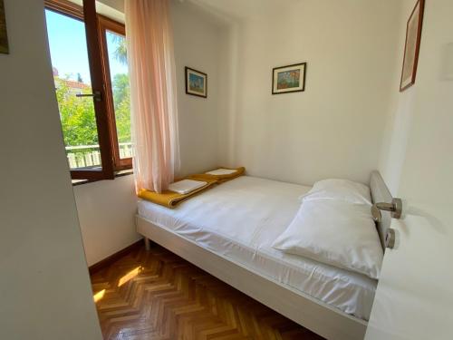 Habitación pequeña con cama y ventana en Apartments Villa Eden, en Preko
