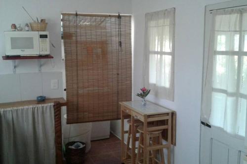 uma cozinha com uma pequena mesa e um micro-ondas em Casa Lola em Barra de Valizas