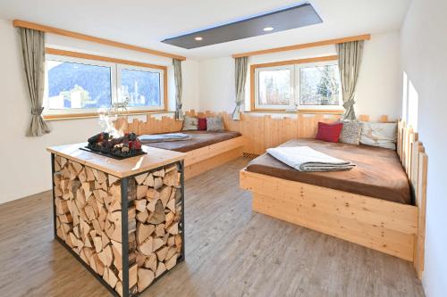 een kamer met 2 bedden en een tafel met houtblokken bij Hotel Sonnfeld in Hinterstoder