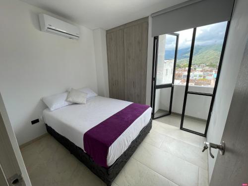 1 dormitorio con cama y ventana con vistas en DIMALU LOFT en Roldanillo
