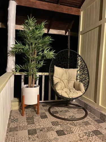 a wicker chair on a porch with a plant at Hotel Villas Gaia Ecolodge in Uvita