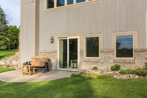 a patio with two chairs sitting next to a house at Cedar House Retreat in Excelsior