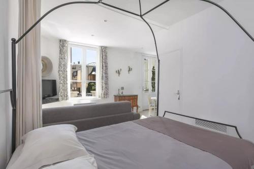 um quarto com uma cama e uma sala de estar em La Terrasse de Mademoiselle em Versailles