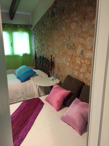 a bedroom with two beds with pink and blue pillows at Ca na Francina in Valldemossa
