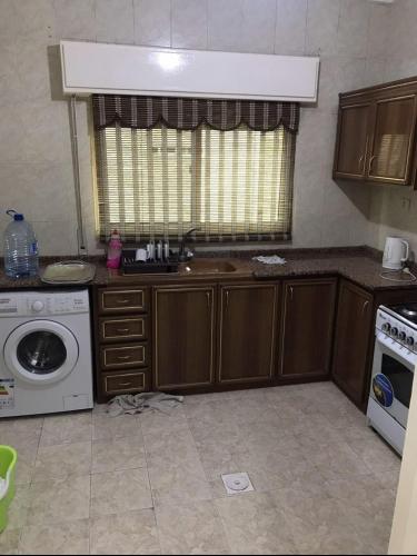 a kitchen with a sink and a washing machine at شقة مفروشة قريبة من البوابة الشمالية للجامعة الاردنية in Amman