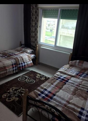 a bedroom with two beds and a window at شقة مفروشة قريبة من البوابة الشمالية للجامعة الاردنية in Amman
