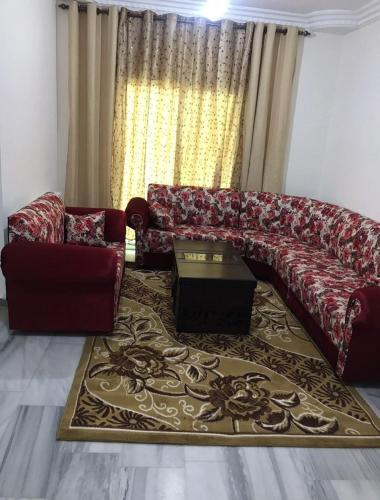 a living room with a couch and a table at شقة مفروشة قريبة من البوابة الشمالية للجامعة الاردنية in Amman