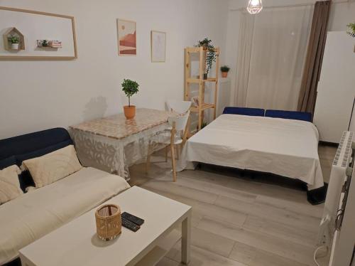 un salon avec deux lits et une table dans l'établissement Charmant appartement avec terrasse proche Paris, à Le Perreux-Sur-Marne