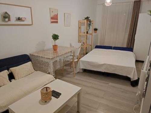 - un salon avec deux lits et une table dans l'établissement Charmant appartement avec terrasse proche Paris, à Le Perreux-Sur-Marne