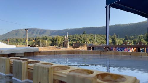 a pool of water with mountains in the background at Cabañas Vista Hermosa Radal 7 Tazas in El Torreón