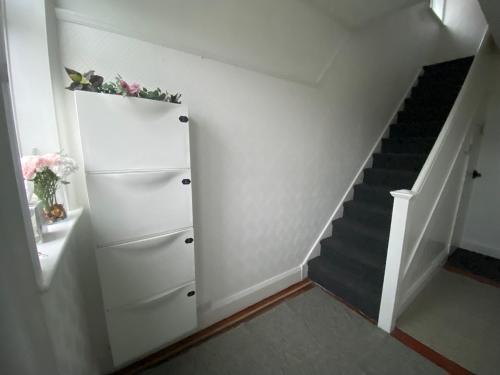 eine Treppe mit einem weißen Schrank und einer Treppe in der Unterkunft Peaceful stay Near Derby City Centre Room 3 in Derby