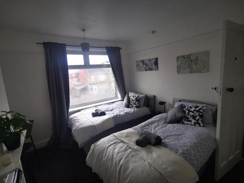 una camera con due letti e una finestra di Peaceful stay Near Derby City Centre Room 3 a Derby