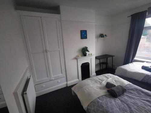 a bedroom with two beds and a fireplace at Peaceful stay Near Derby City Centre Room 3 in Derby
