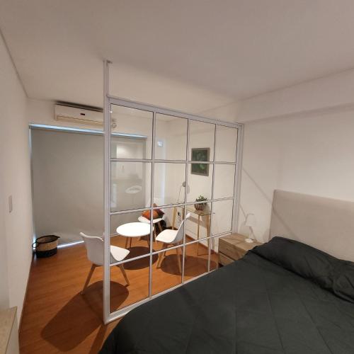 Zimmer mit einem Tisch und Stühlen sowie einem Zimmer mit einem Bett in der Unterkunft Salta Hills 2 in Salta