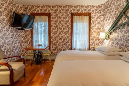 a hotel room with two beds and a tv at Albergo Allegria Hotel & Breakfast Restaurant in Windham