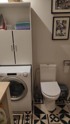 een badkamer met een toilet en een wasmachine bij Cosy Tavira Holidays in Tavira