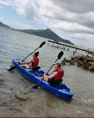 two people in a blue kayak on the water at Paraíso da Enseada de Brito in Palhoça