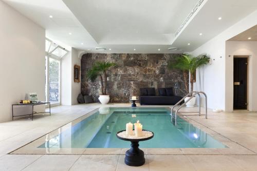 a swimming pool in a living room with a table and candles at Villa Marina Capri in Capri