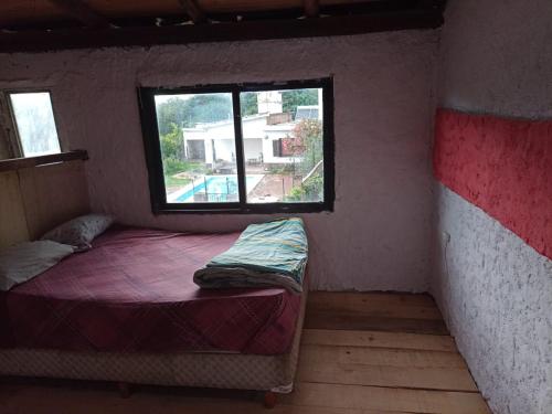 Habitación pequeña con cama y ventana en Casa CAMALDALU en Unquillo