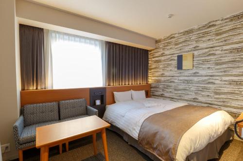 Pokój hotelowy z łóżkiem i krzesłem w obiekcie Keisei Hotel Miramare w mieście Chiba