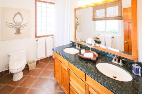 W łazience znajduje się umywalka, toaleta i lustro. w obiekcie Coral Vista #4 - 50546 Home w mieście West End