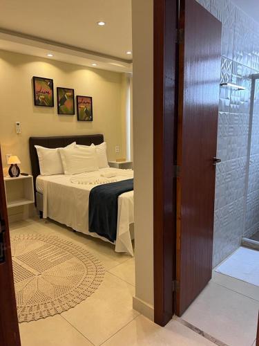 a bedroom with a large bed with white pillows at Pousada Arraial Tropical in Arraial do Cabo