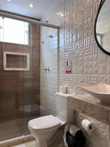 a bathroom with a toilet and a sink and a shower at Pousada Arraial Tropical in Arraial do Cabo